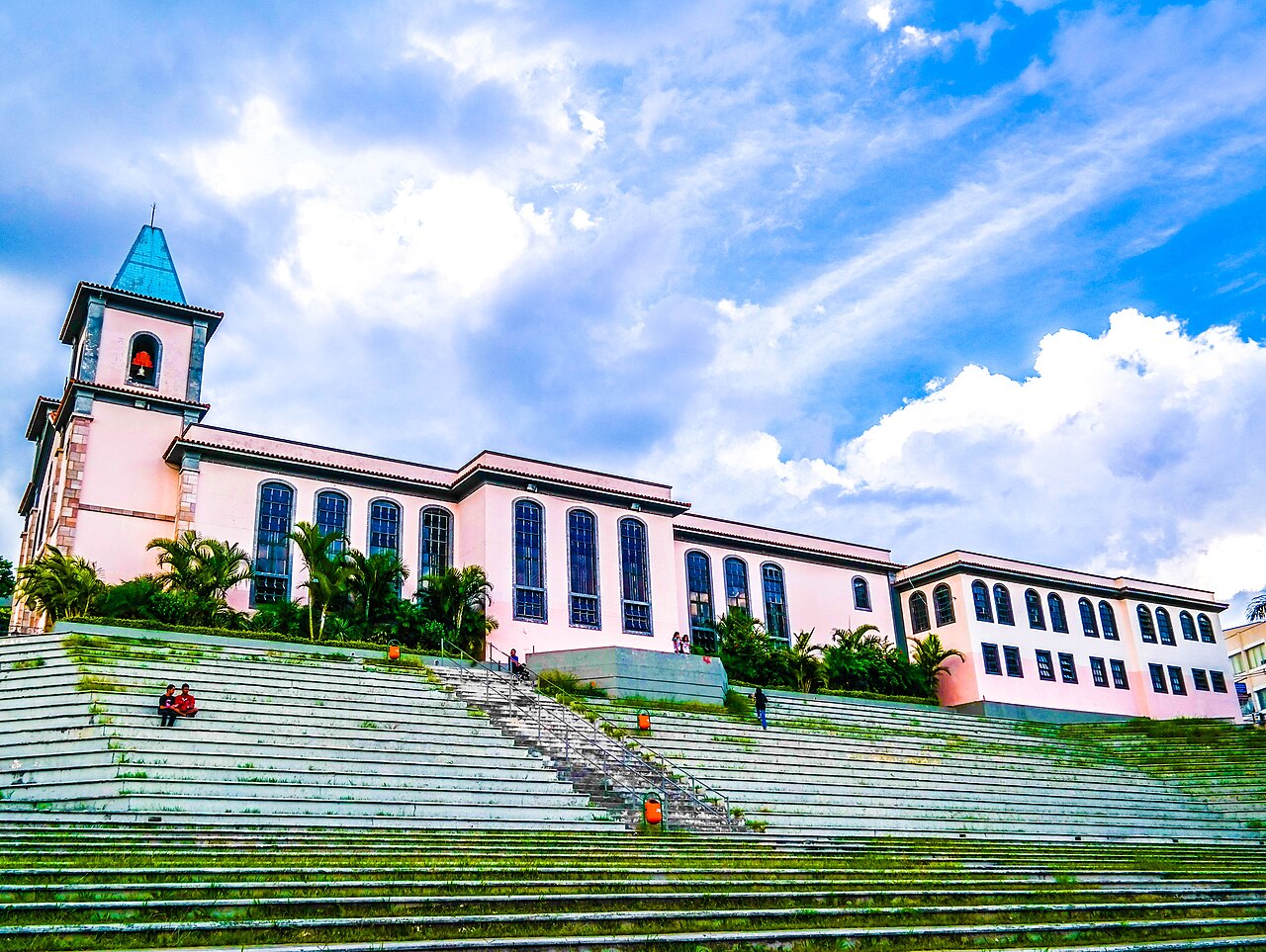 Igreja Matriz de São Gonçalo, no centro histórico de Contagem, Minas Gerais, vista da escadaria gramada sob céu com nuvens